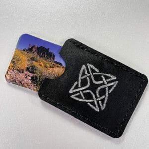 Hand-stitched black cactus leather card case with an engraved and painted silver square Celtic knot, business cards with an image of Lost Dutchman Mountain protrude from the end.