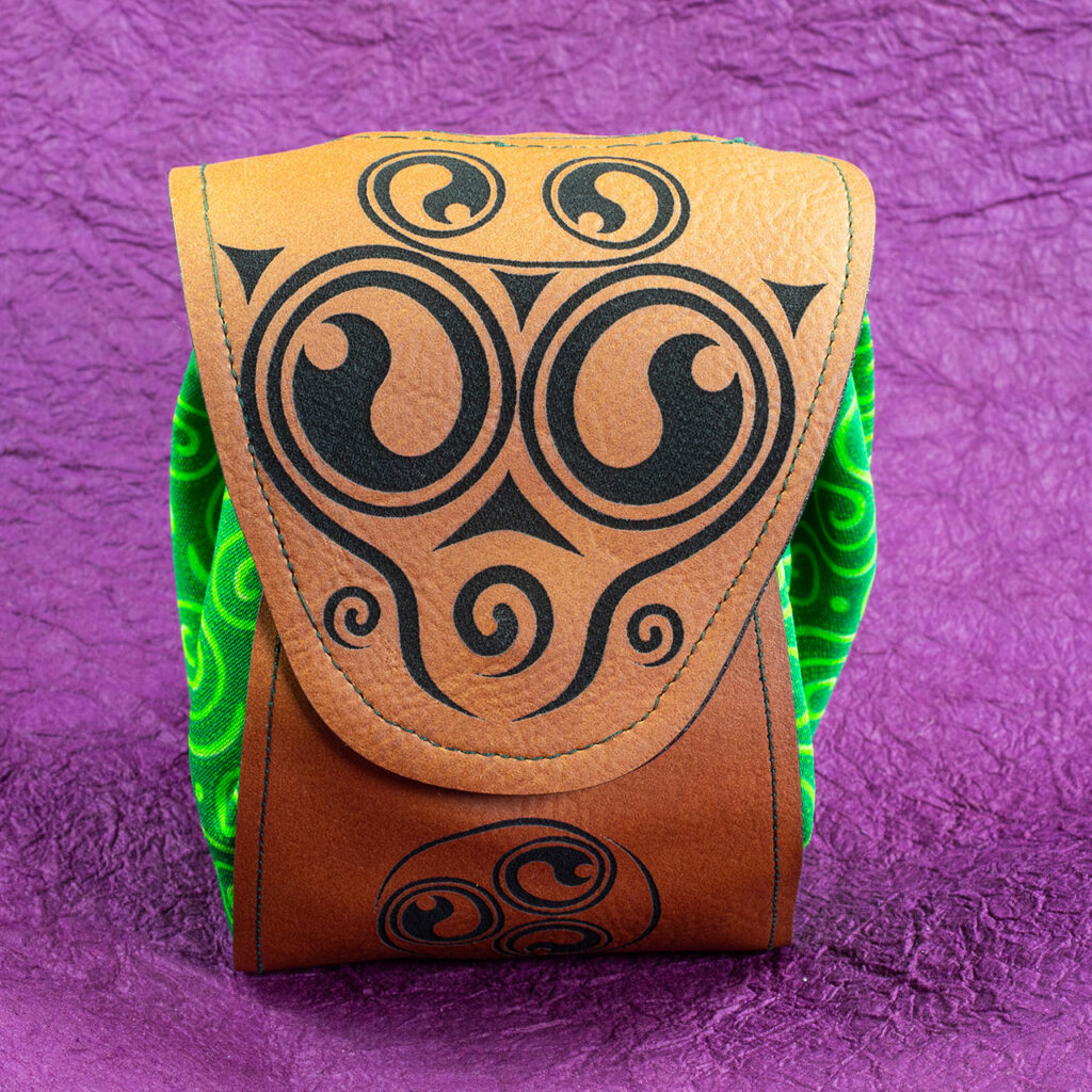 A small fantasy/Medieval belt pouch. The main body is cotton fabric printed with interlocking Celtic spirals in various shades of green. The front, bottom, back and flap are medium brown faux/vegan leather. The flap is decorated with black spirals and, there is a black spiral triskelion on the front below the flap.