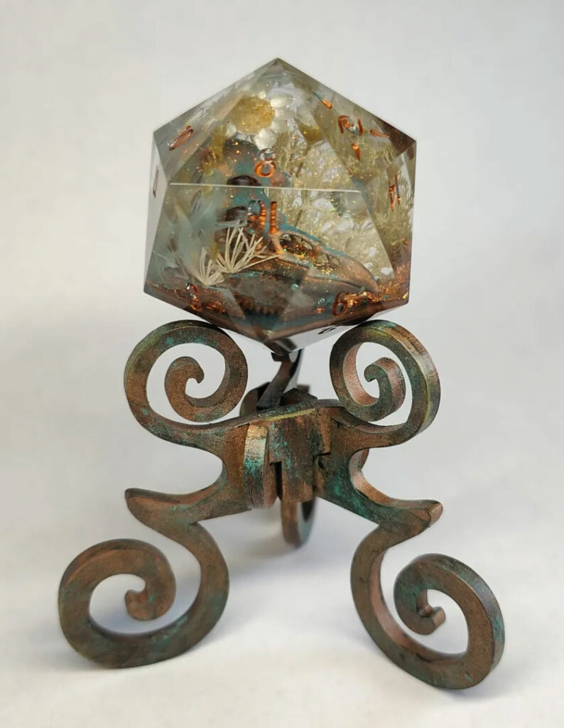 Resin art D20 chonk by @DiceOfTheSeeker on faux copper patina reliquary.
