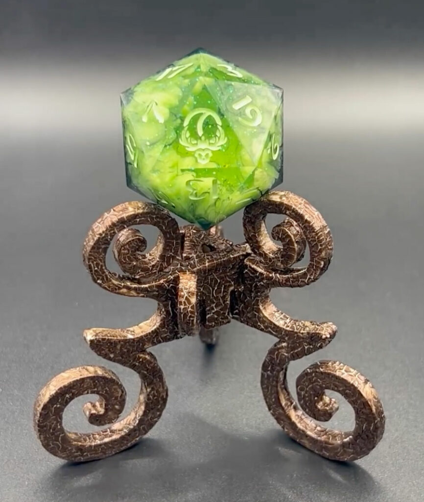 Bronze Crackle Reliquary dice stand with green Necromancy D20 Chonk from False Life Dice.