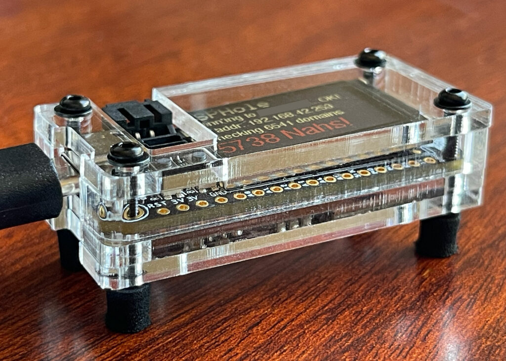 ESP32-S2 TFT Feather running ESPHole in a custom laser-cut acrylic case (3/4 front view).