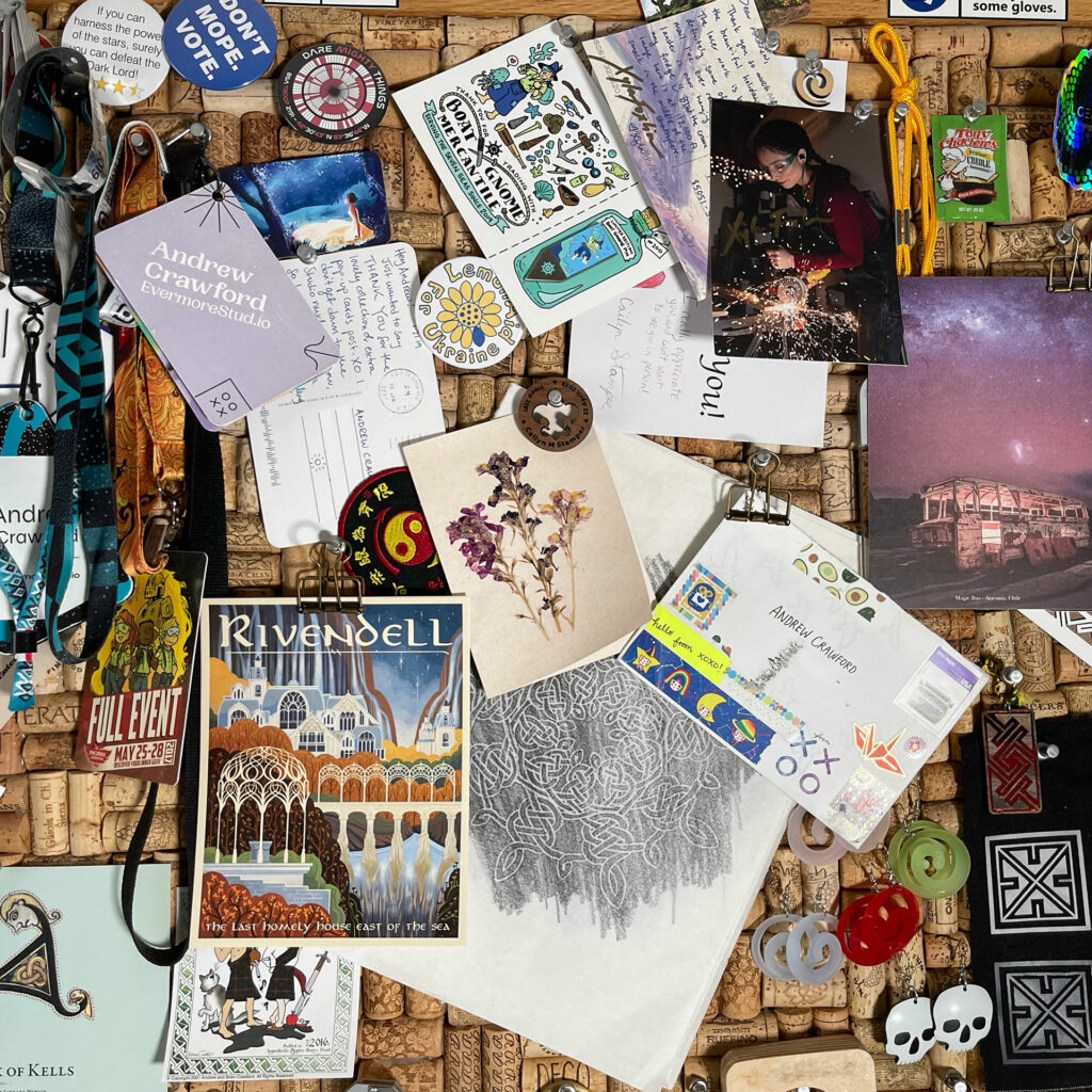 A section of a cork board covered with paper ephemera, pins, buttons, stickers, postcards, small handmade items too numerous to enumerate.