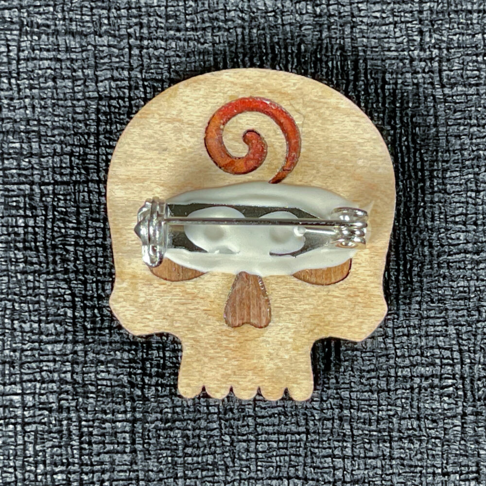 Light-colored skull pin reverse showing the pin backing.