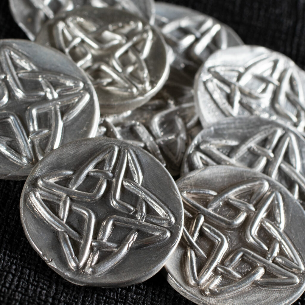 Small silver medallions with 3D Celtic knotwork.