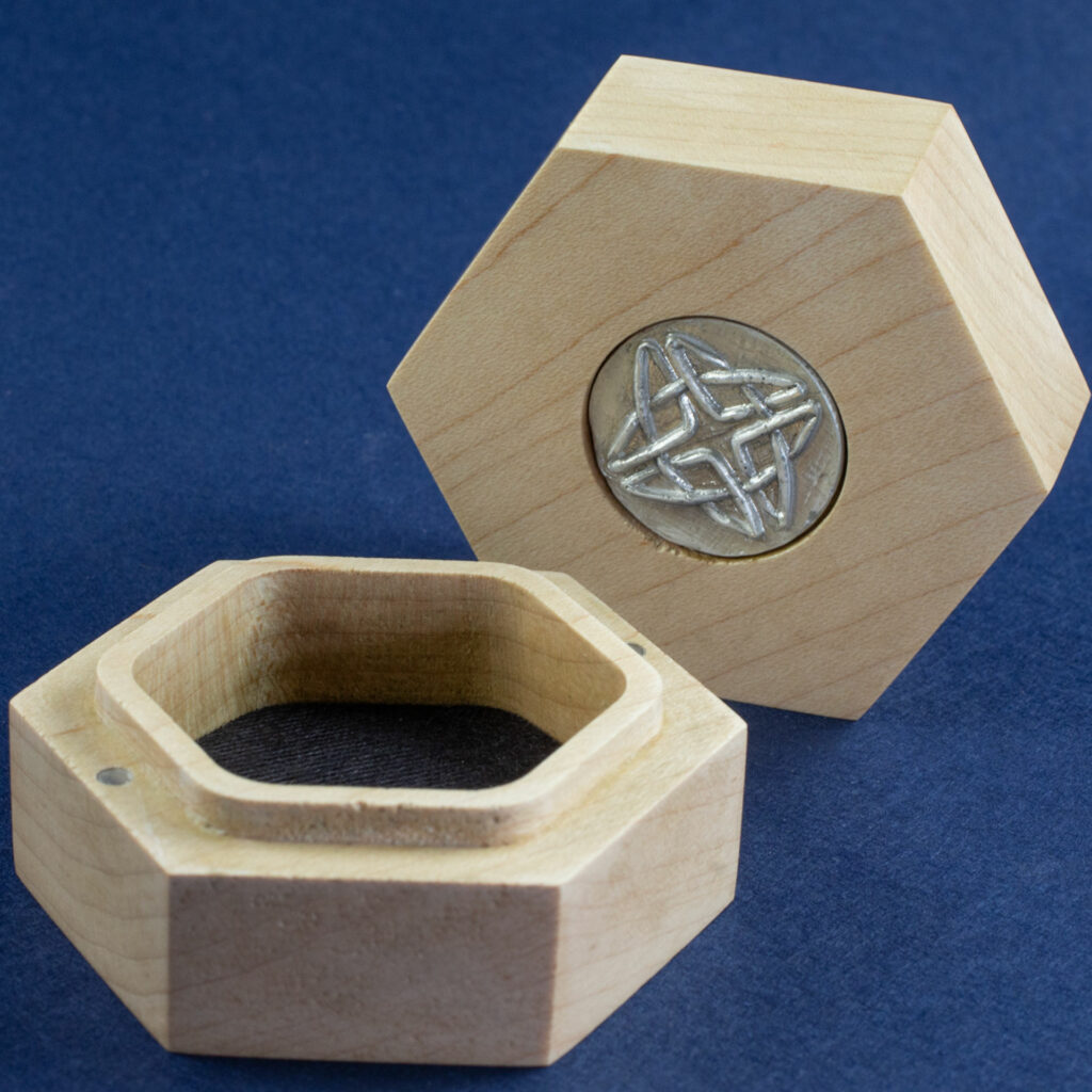 Oak Hex Chonk Box with a silver Celtic knotwork medallion in the lid, open and empty.