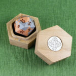 Cherry Hex Chonk Box with a silver Celtic knotwork medallion in the lid, open with a silver and copper 20-sided Jesmonite die inside.