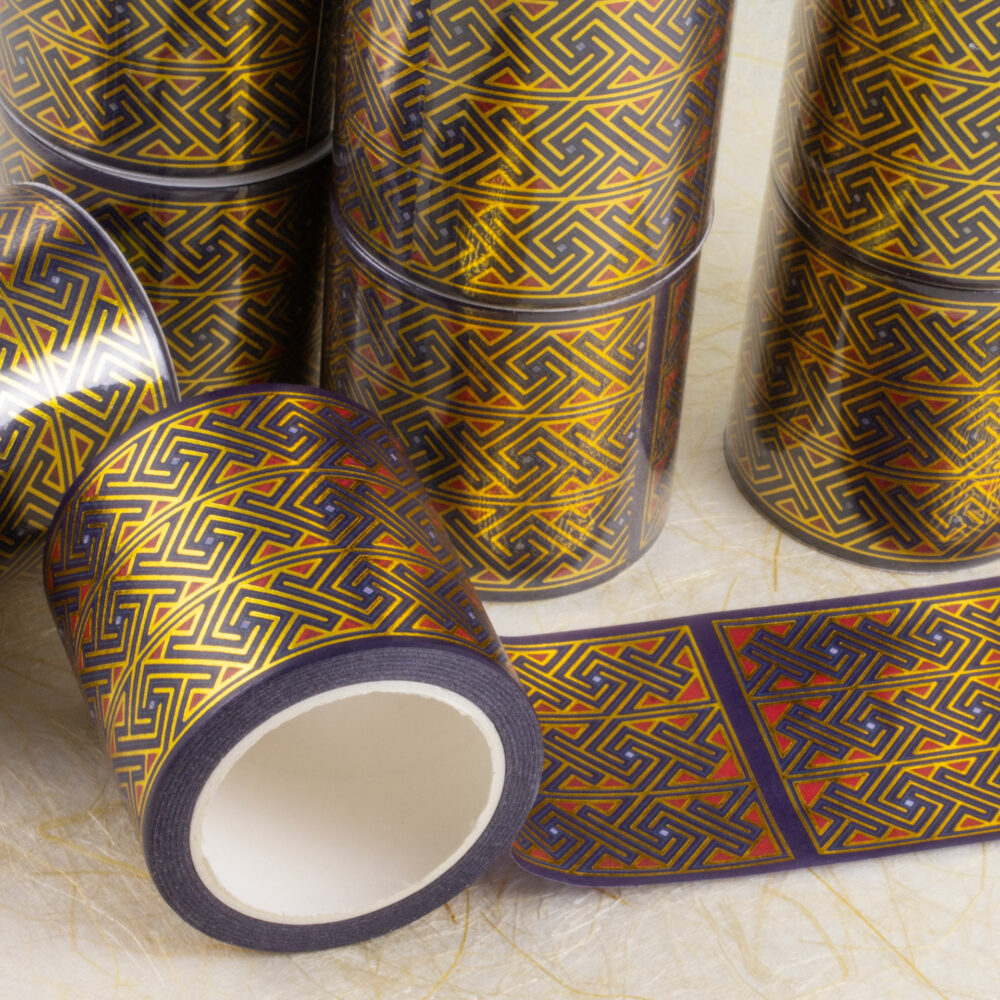 Rolls of 45mm-wide washi tape with Celtic key patterns in gold foil on deep purple with red and light blue accents.