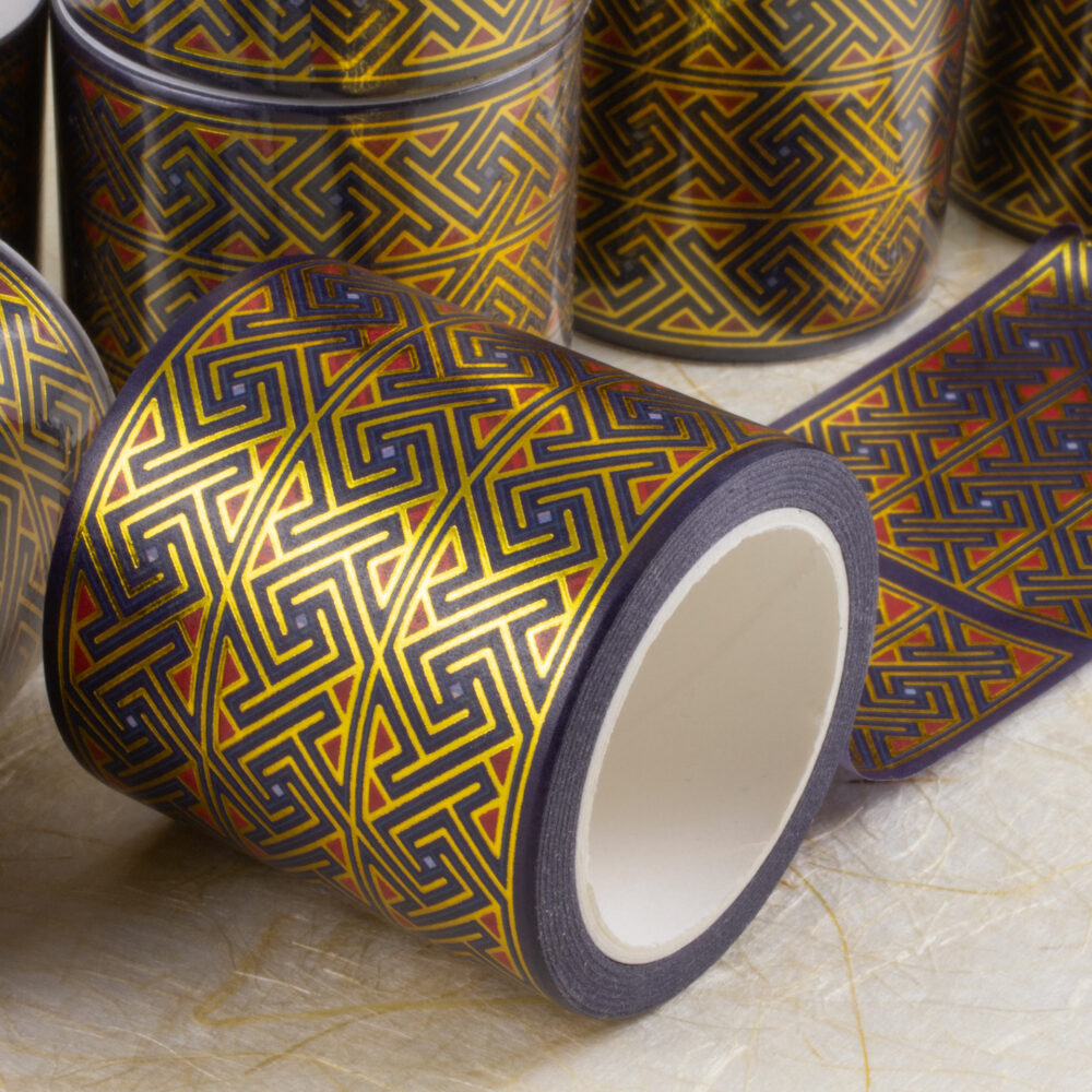 Rolls of 45mm-wide washi tape with Celtic key patterns in gold foil on deep purple with red and light blue accents.