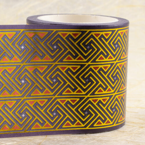 Roll of 45mm-wide washi tape with Celtic key patterns in gold foil on deep purple with red and light blue accents.