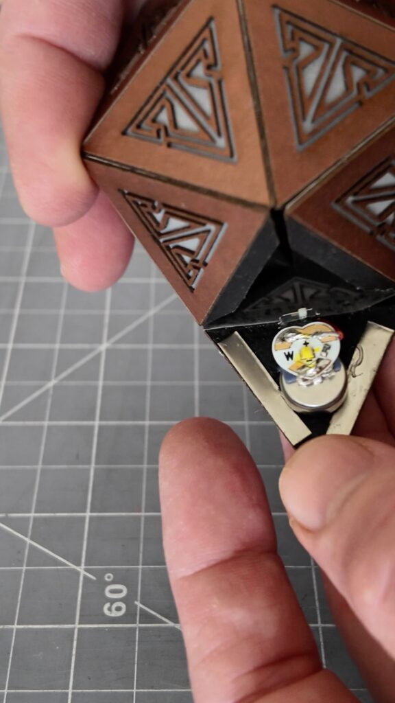 Copper rechargeable icosahedron with the magnetically closeable panel open showing the tiny light inside